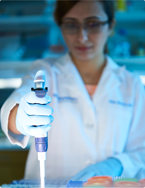 Doctor using a pipette during a medical experiment in a research lab
